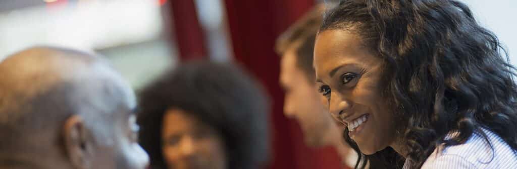 Woman smiling at a colleague at a conference.